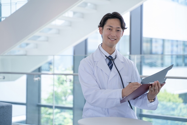 白衣を着た男性医師が微笑んでいるところ